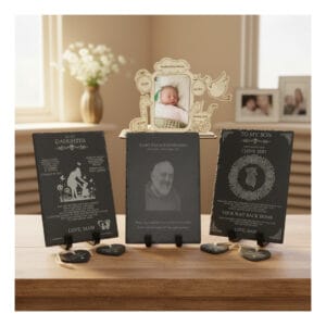 Three large slate plaques on stands and wooden picture frame with new born baby details engraved behind them , all sitting on a table with a vase and pictures on a in the background.